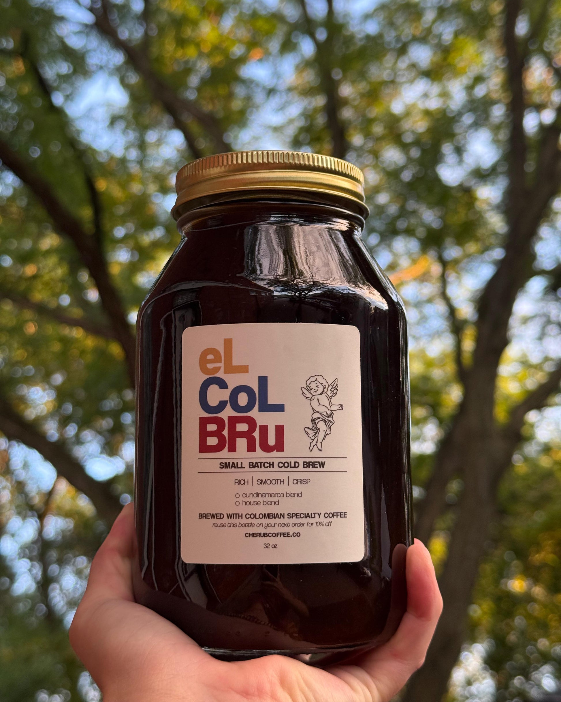 Jar of El Col Bru held in front of trees.